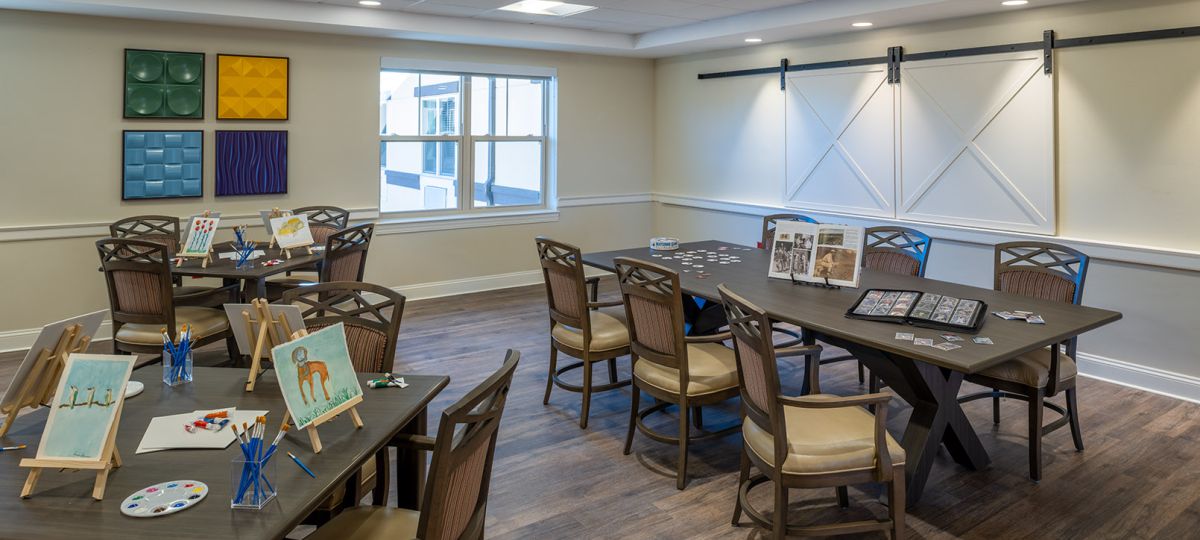 Wide-angle shot of a bright and spacious dining area in an Erickson community building, featuring modern furnishings and an inviting atmosphere.