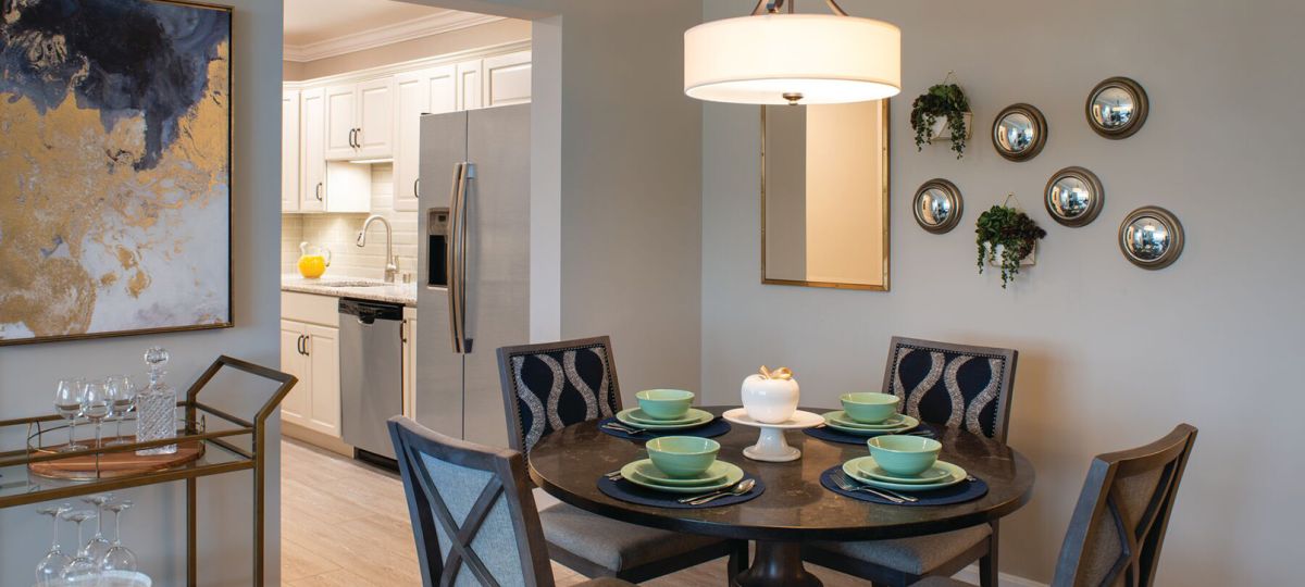 Modern kitchen in an Erickson Senior Living community apartment with updated appliances and circular breakfast table with seating for four.