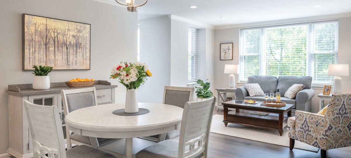 Wide angle shot of a spacious, open living room and dining area in an Erickson apartment.
