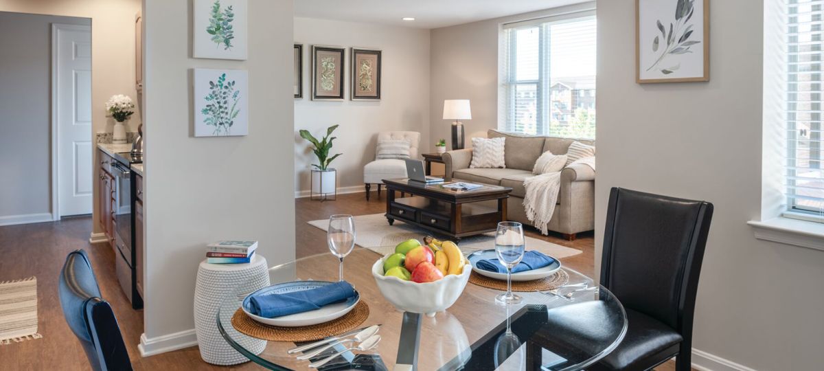Wide angle shot of a spacious, open living room and dining area in an Erickson apartment.