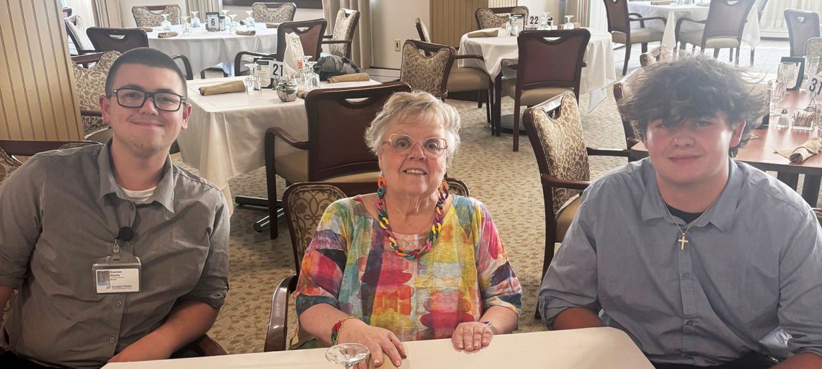 Resident Carol DeSouza, pictured with student servers Connor Harris (left) and Christian Jacobson (right)