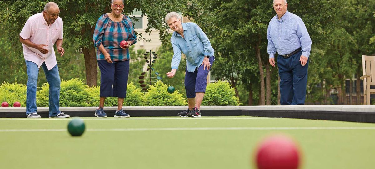 4 residents having a spirited game of bocce ball