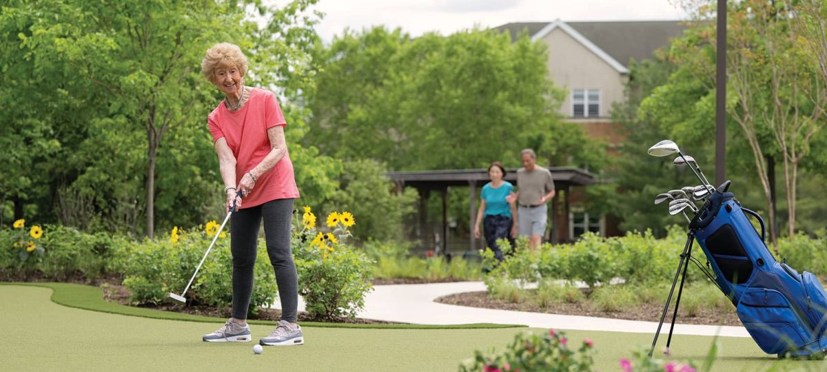 Resident golfing, 2 residents walking on a path
