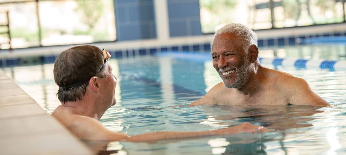 2 residents talking in the pool