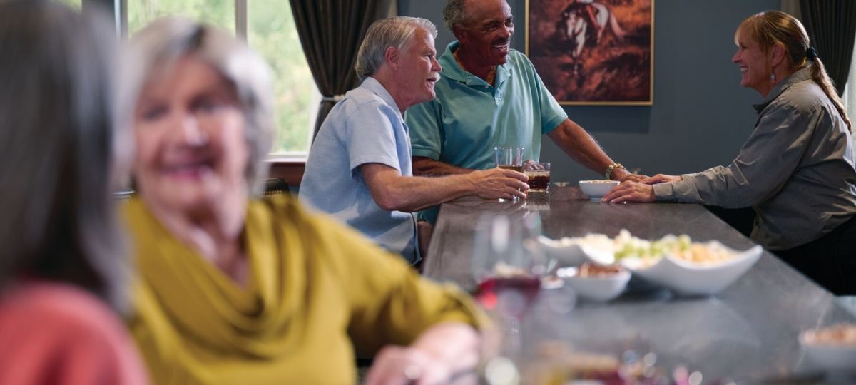 Residents socializing at a community bar area, enjoying drinks and conversation in a warm and relaxed setting.