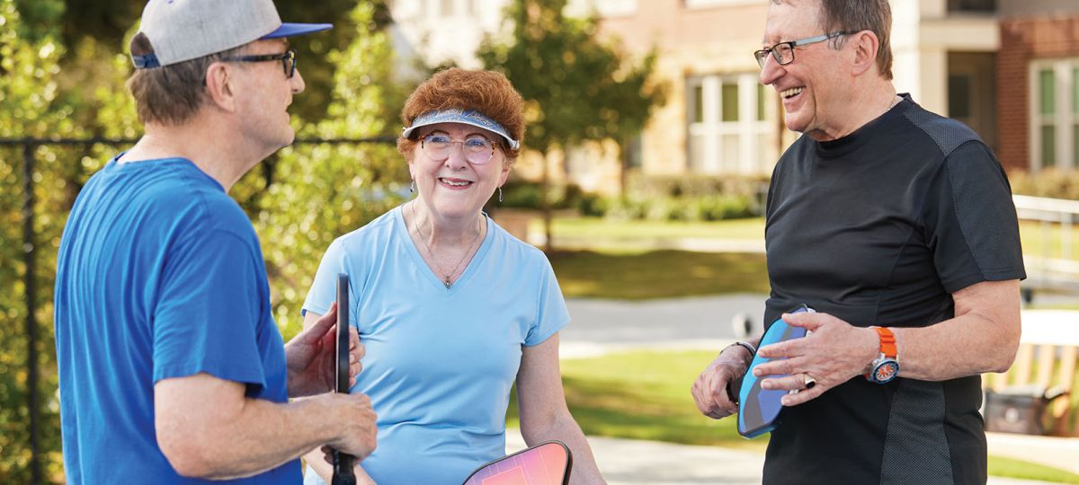 Three Residents Talking on a pickleball court