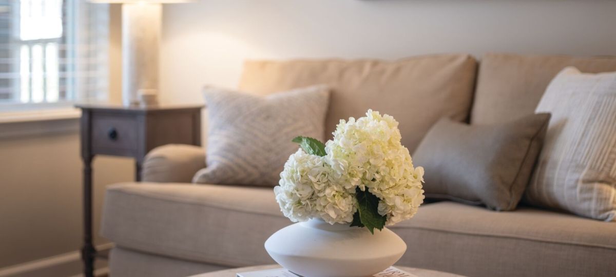 Cozy living room with neutral sofa, coffee table decor, soft lighting, and warm modern styling.