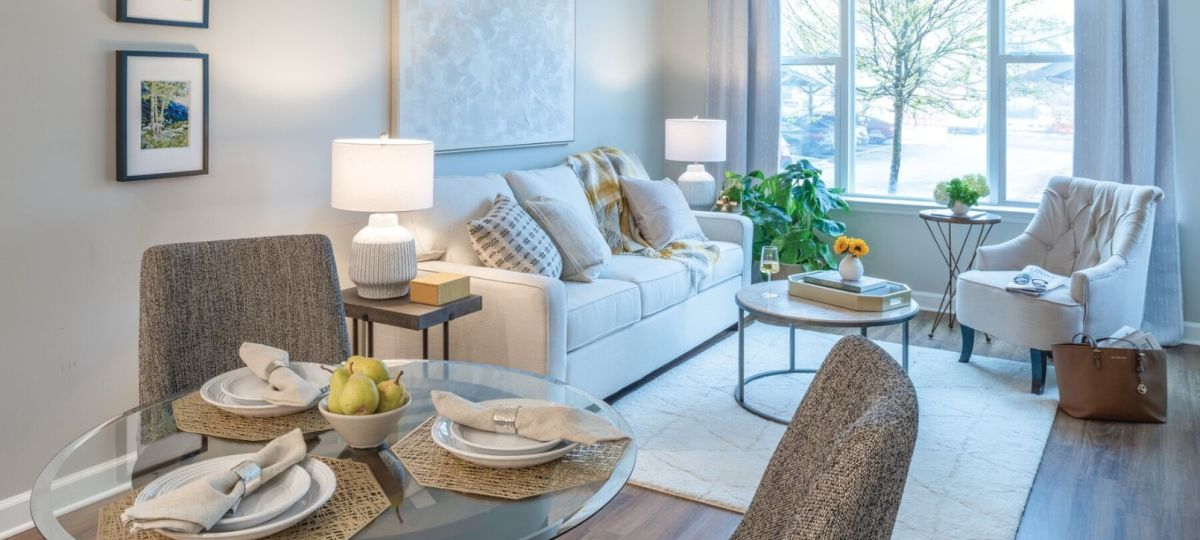 Modern living and dining area with large windows, contemporary furniture, and warm natural light.