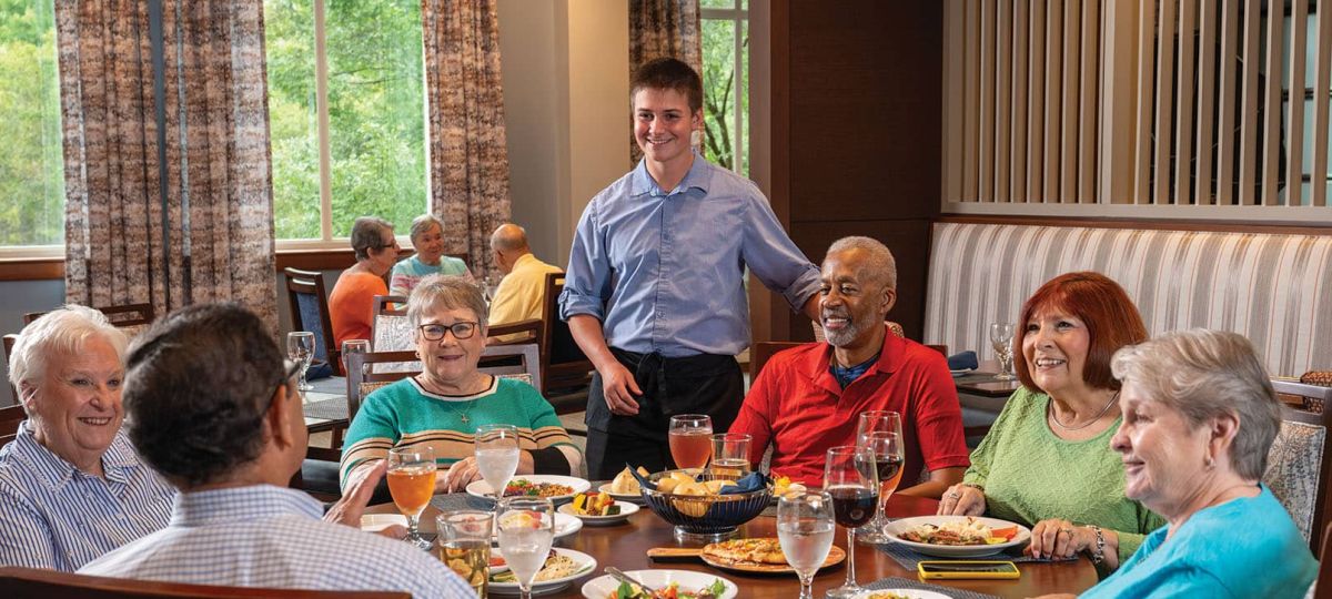 Maris Grove residents having a conversation with a server in the dining area