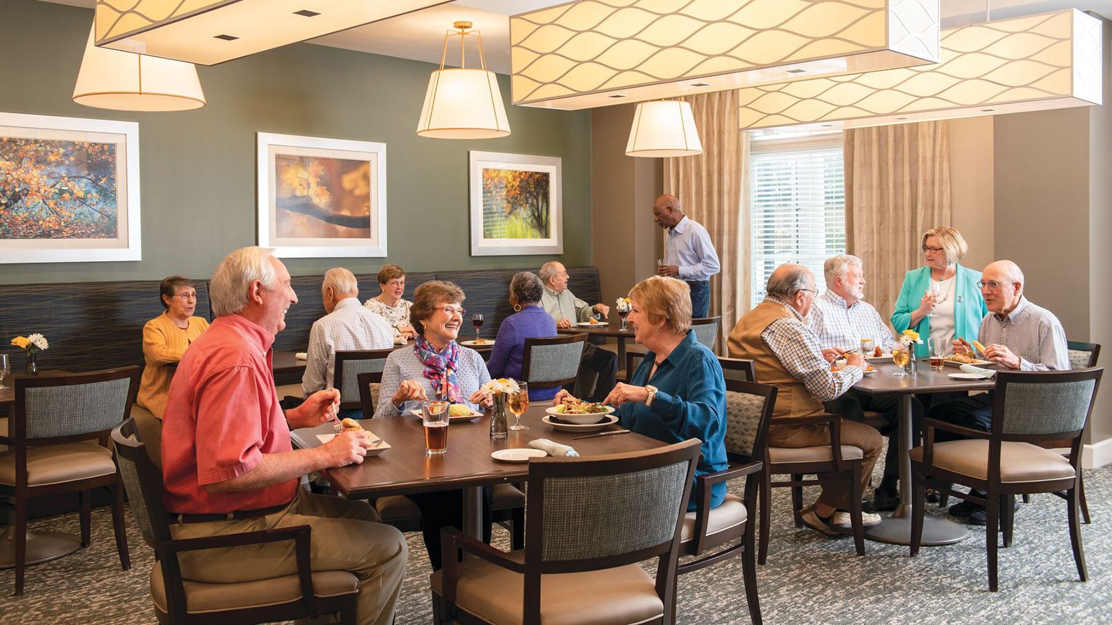 Community residents enjoying lively conversation while dining in community restaurant