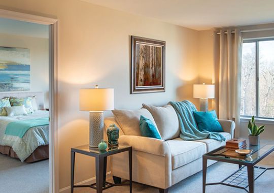 Spacious living room with view into large bedroom.