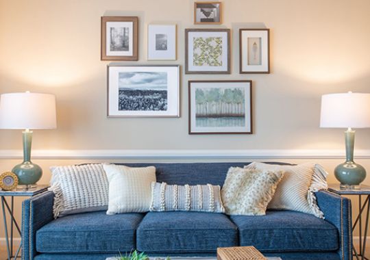 Large seating area beneath a modern photo arrangement.