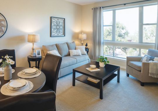 Wide shot of dining room and spacious, open living room.