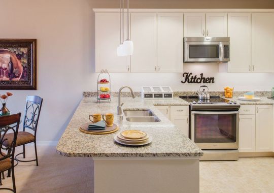 Wide shot of a spacious kitchen with breakfast bar.
