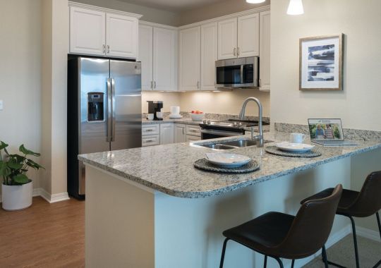 Interior shot of kitchen and breakfast bar inside of an Erickson two-bedroom apartment home.