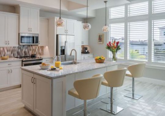 Interior shot of a spacious kitchen and bar with seating inside of an Erickson two-bedroom apartment home.
