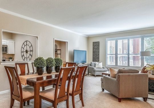Wide angle shot of a spacious, open living room and dining area in an Erickson apartment.