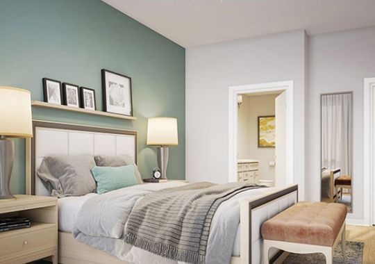 Spacious bedroom with modern furniture and decorations in an Erickson two-bedroom apartment.