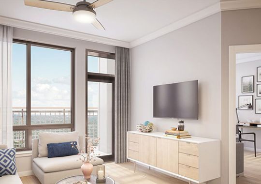Wide angle shot of a spacious, open living room with balcony views of downtown Bethesda.