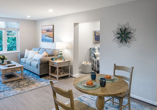 Living room and dining area in an Erickson Senior Living apartment, showcasing modern furnishings and open layout.