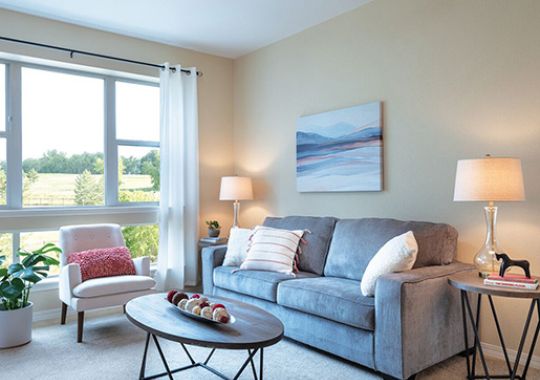 Bright, well-furnished living room in an Erickson Senior Living apartment.