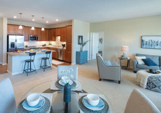 Wide angle shot of a spacious, open living room and dining area in an Erickson apartment.