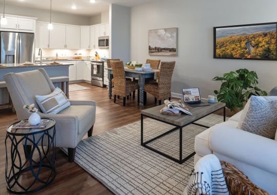 Wide angle shot of a spacious, open living room and dining area in an Erickson apartment.