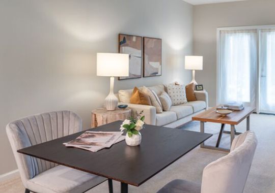 Modern Erickson Senior Living apartment with a small dining table, plush chairs, and a cozy living area.