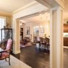 Stately open concept floor with decorative molding and dark wooden floors.