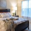 Sunny bedroom containing a large bed and dresser.