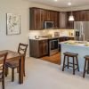 Interior shot of kitchen, breakfast bar and dining room inside of an Erickson two-bedroom apartment home. 