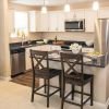 Interior shot of a kitchen with stainless steel appliances and breakfast bar in an Erickson two-bedroom apartment. 