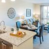 Interior shot of kitchen facing a bright, furnished spacious living room. 