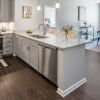 Interior shot of a bright kitchen with sit in dining area in the Maplewood apartment.