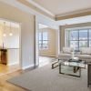 Wide shot of an open, sunny, living room in an one-bedroom apartment. 