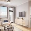 Wide shot of a nicely decorated, modern living room with balcony views of downtown Bethesda.