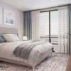 Spacious bedroom with modern furniture and decorations in an Erickson two-bedroom apartment. 