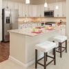 Modern kitchen in an Erickson Senior Living community apartment with stainless steel appliances and counter seating.