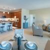 Wide angle shot of a spacious, open living room and dining area in an Erickson apartment. 