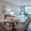 Wide angle shot of a spacious, open living room and dining area in an Erickson apartment. 