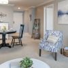 Wide angle shot of a spacious, open living room and dining area in an Erickson apartment. 