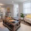 Wide angle shot of a spacious, open living room and dining area in an Erickson apartment. 