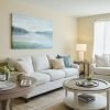 Comfortable and well-furnished living room with comfortable, white couch and sofa, with a large balcony window.