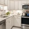 Contemporary kitchen in an Erickson Senior Living apartment, showcasing sleek stainless steel appliances and stylish white cabinetry.