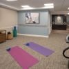 Fitness and wellness room with exercise mats, dumbbells, stationary bikes, and a balance barre along the wall.