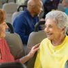 Older adults chatting and smiling while riding together in a community shuttle bus.