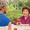 2 residents talking outside with drinks