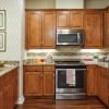 Modern kitchen with wood cabinetry, granite countertops, stainless steel appliances, and pendant lighting.