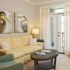 Cozy living room with soft neutral decor, accent seating, and balcony access through glass doors. 
