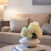 Cozy living room with neutral sofa, coffee table decor, soft lighting, and warm modern styling. 